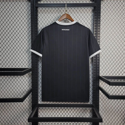 Back view of NEW ZEALAND 2026 HOME jersey displayed on a hanger against a grid backdrop.